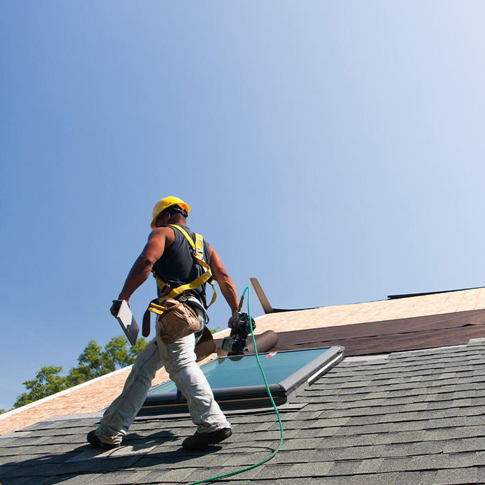 Roofer installing flashing on skylight